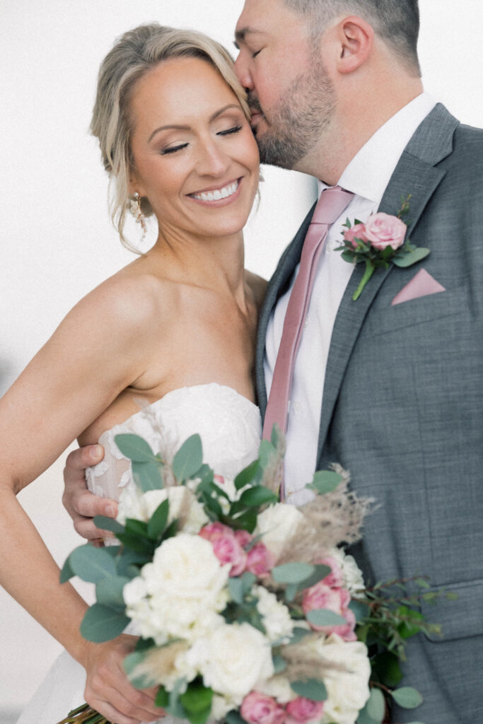 heron hill wedding | groom kissing bride while bride is smiling