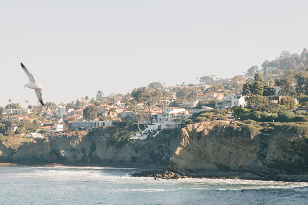 luxury destination wedding photographer | Mountain side with houses at the ocean