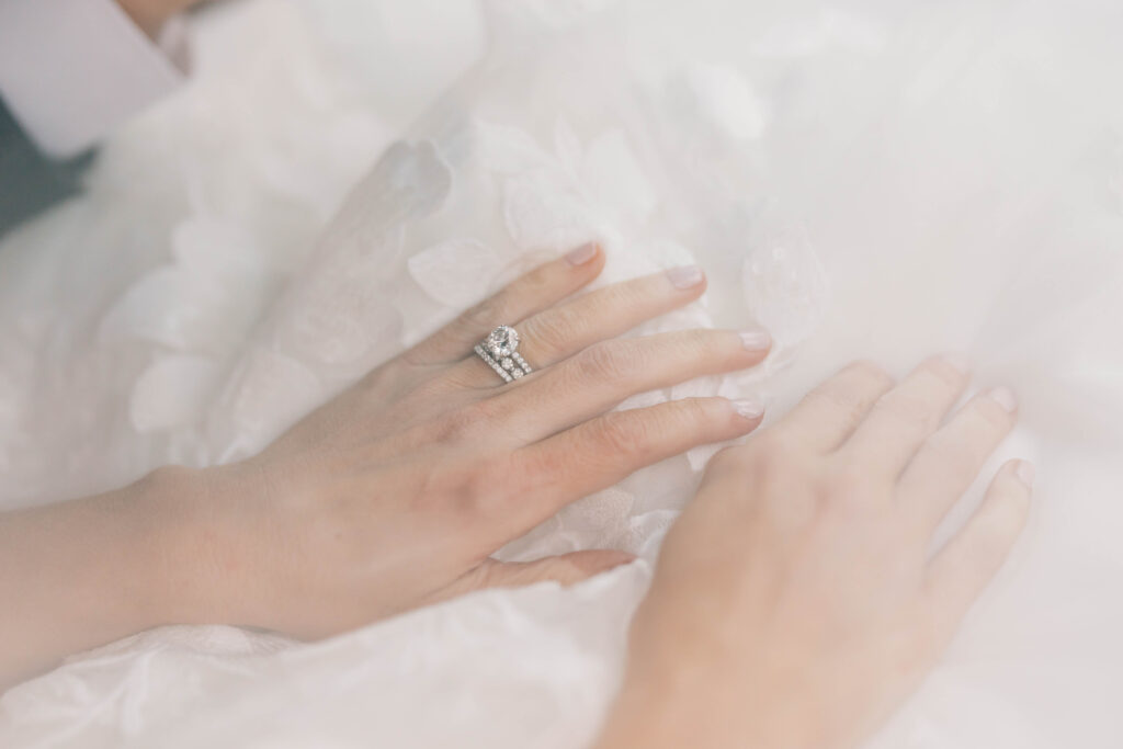 luxury wedding photographers | Brides hands placed in lap with lace dress