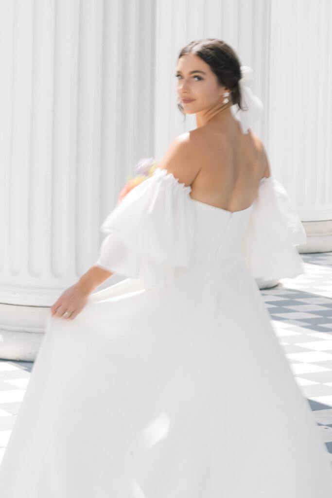 light and airy wedding photography bride looking behind holding dress