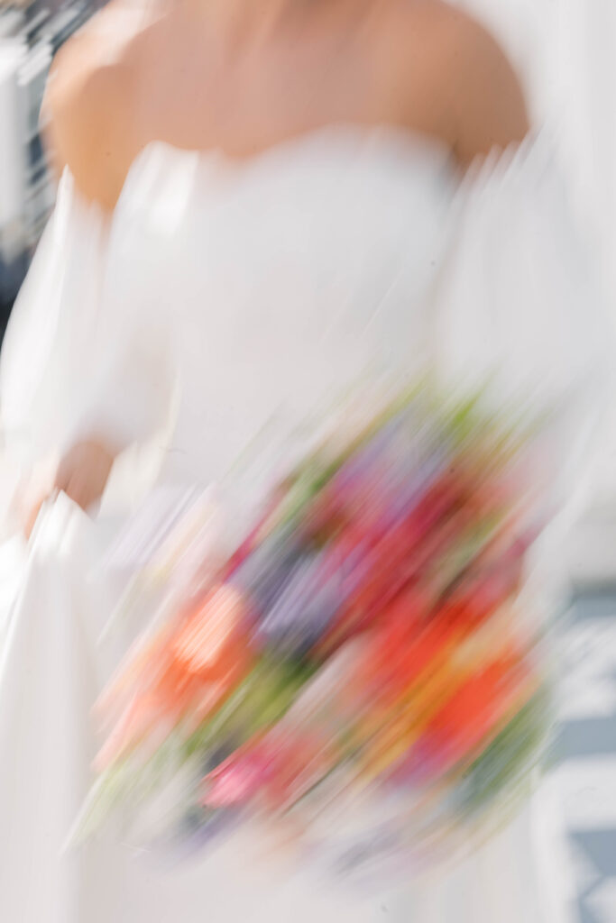 light and airy wedding photography blurry photo of bride running with florals