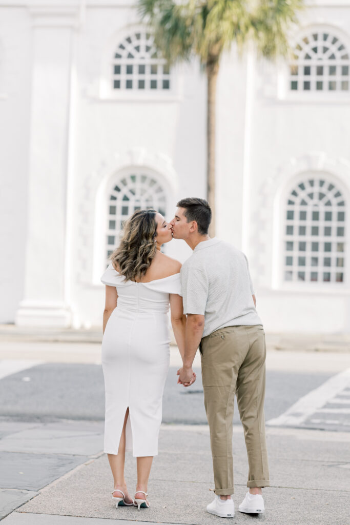 Engagement Photo Ideas in Charleston SC couple kissing in the street with a palm tree in background