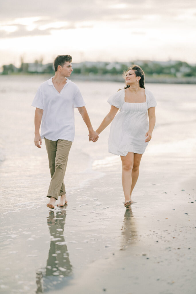 Engagement Photo Ideas in Charleston SC couple walking and looking at each other on beach