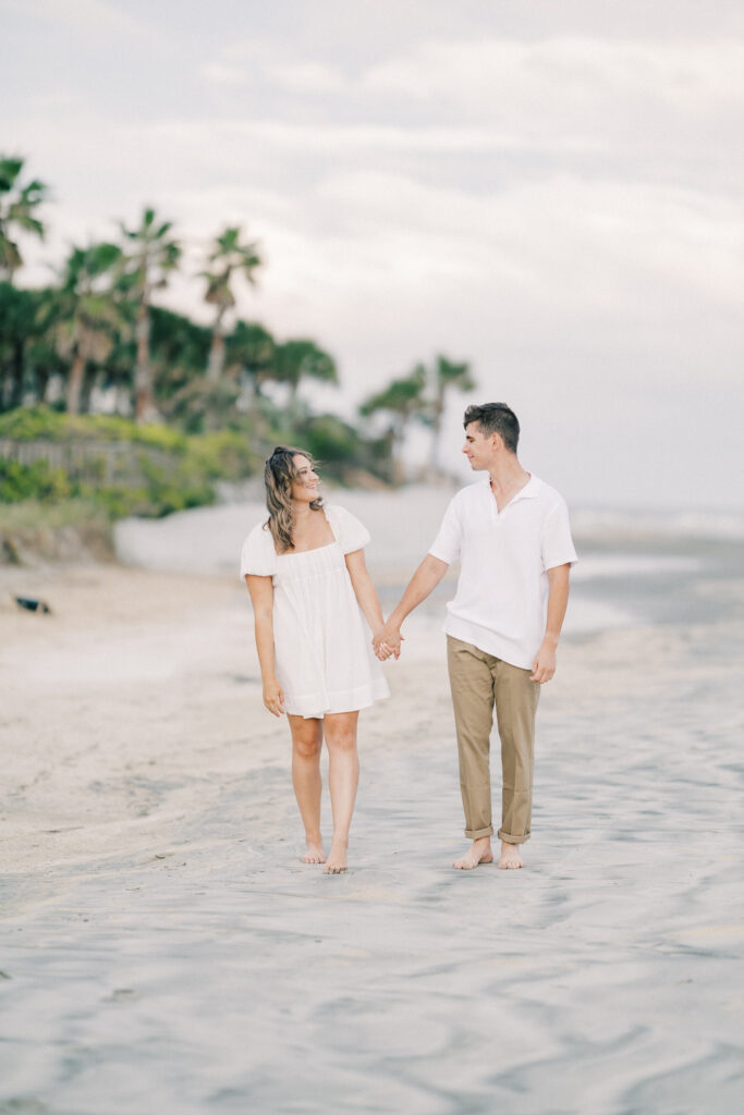 Engagement Photo Ideas in Charleston SC couple holding hands and looking at each other and looking at each other