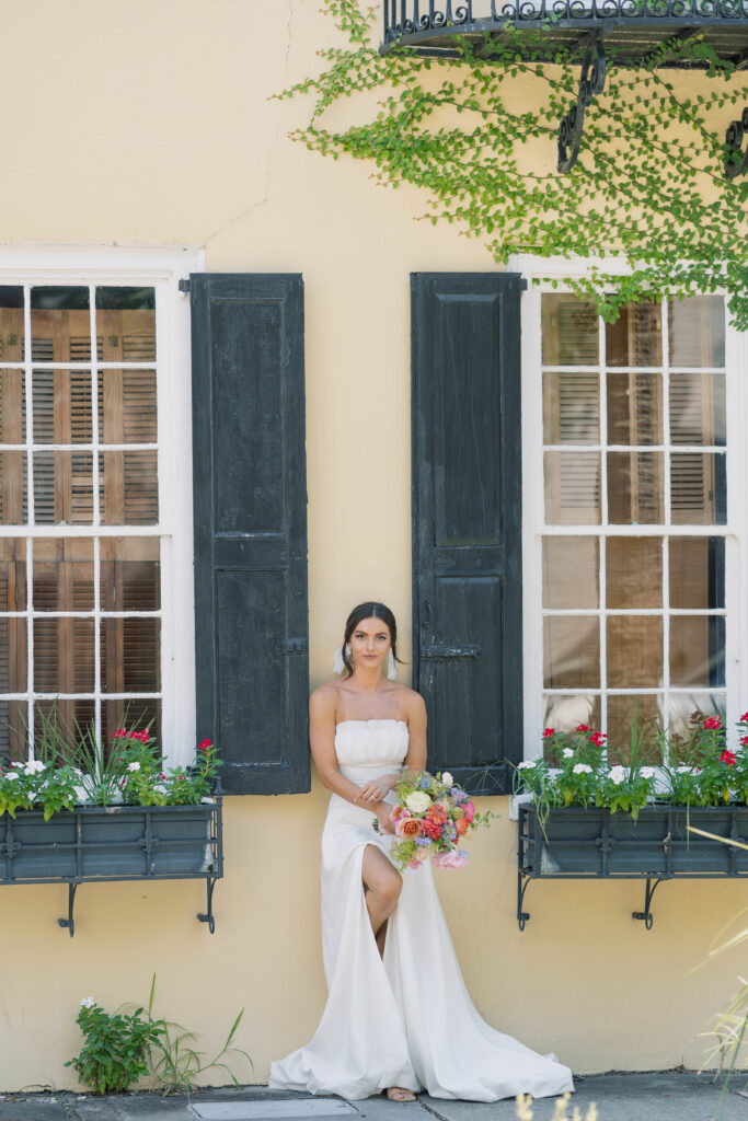 charleston sc wedding photographer | bride in front of yellow building with flower windows