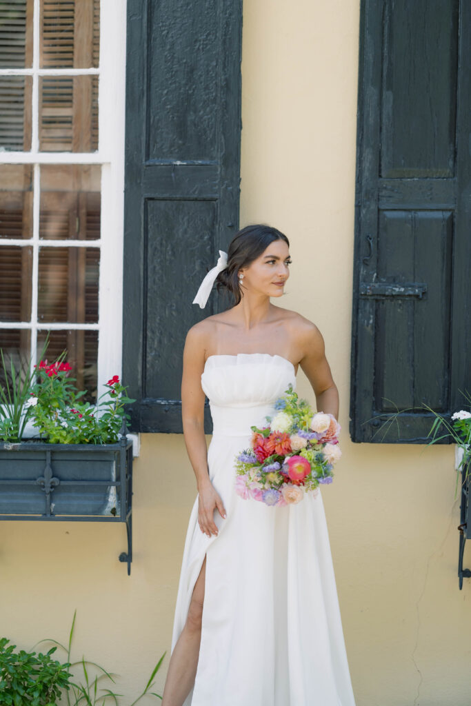 charleston sc wedding photographer | bride in front of yellow building with flower windows