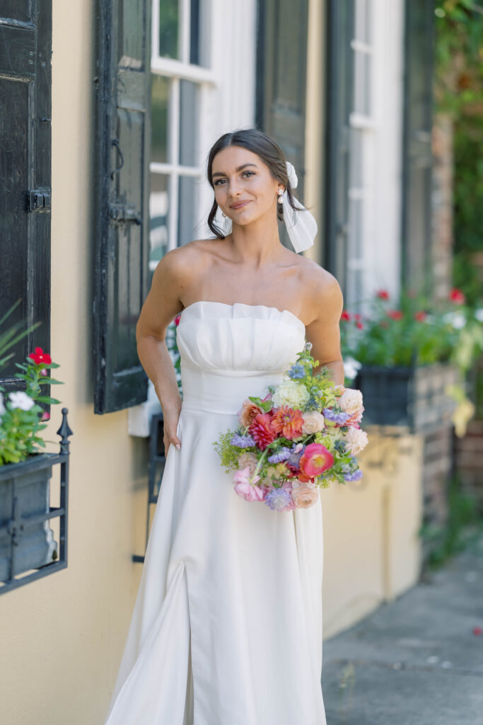 charleston sc wedding photographer | bride in front of yellow building with flower windows