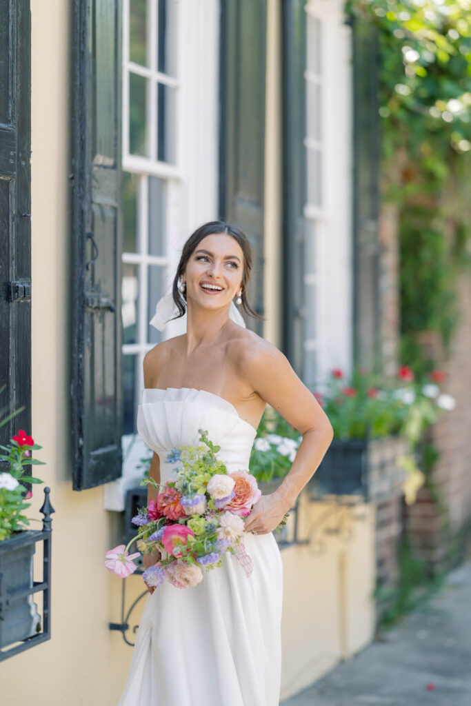 charleston sc wedding photographer | bride in front of yellow building with flower windows