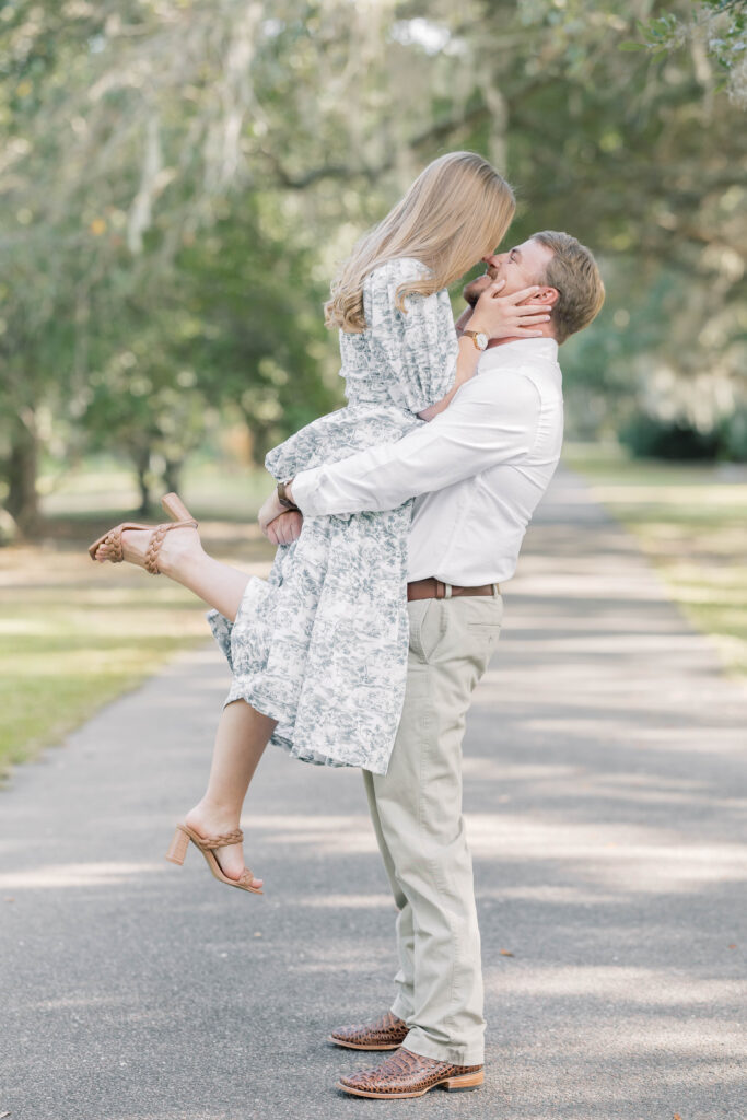 Engagement Photo Ideas in Charleston SC man picking up woman in magnolia gardens