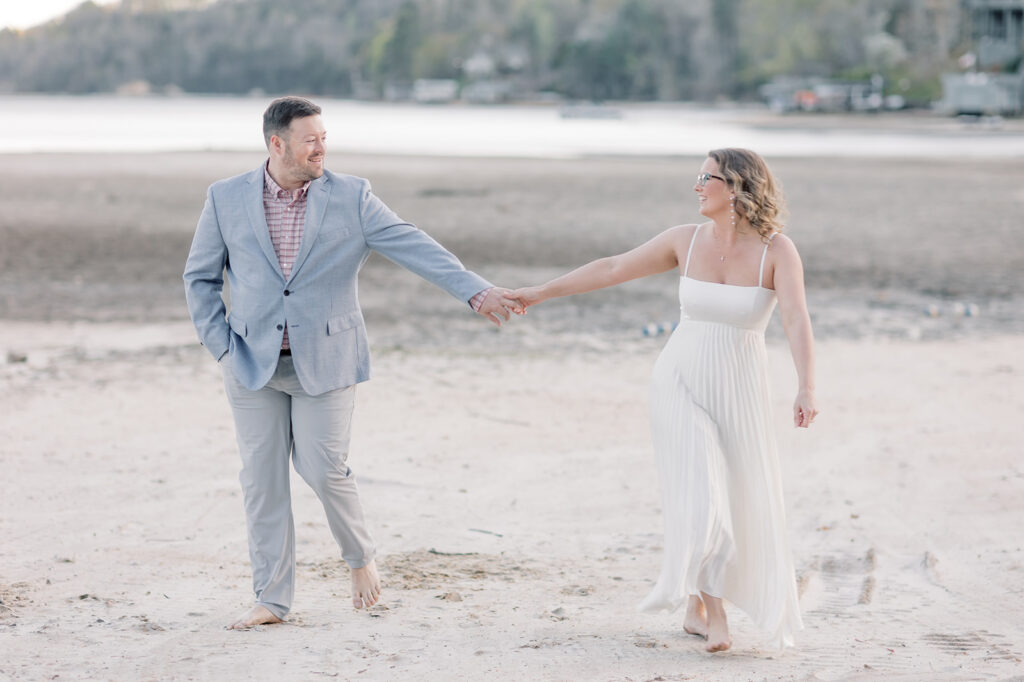 Engagement photographer near me | Couple holding hands on beach