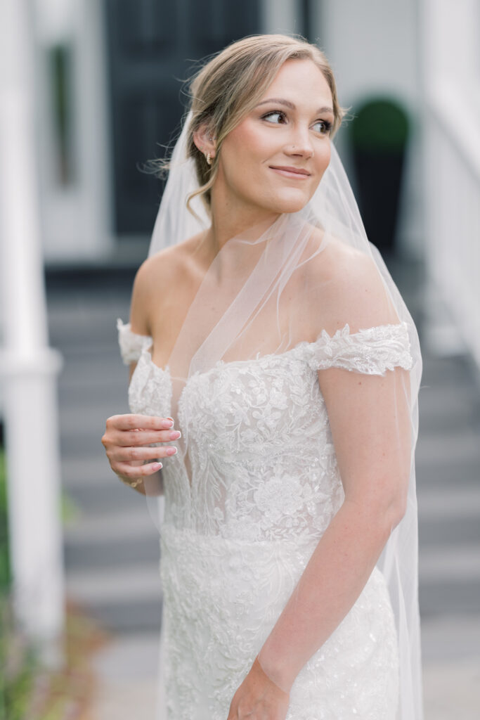 Bridal Portraits | Bride looking out holding veil at southern oaks wedding venue