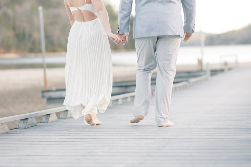 Engagement photos near me |  couple holding hands walking on dock at lake lure