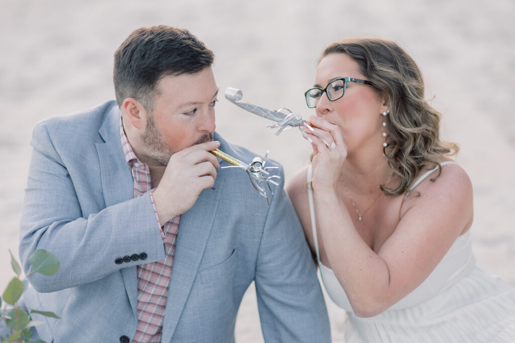 Engagement photographer near me | couple blowing party favors