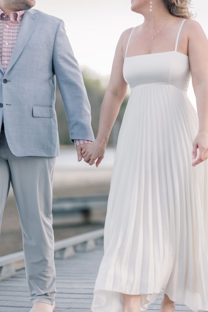 Engagement photographer near me | Couple holding hands on dock in lake lure