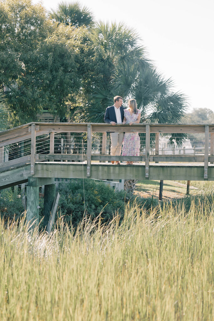 Charleston SC engagement photos | couple looking at each other in front of marsh on boardwalk