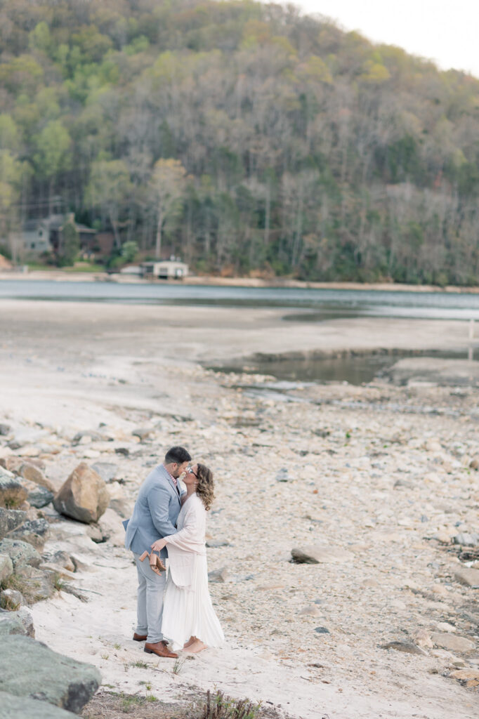 Engagement photographer near me | couple wrapped around each other on the beach of lake lure