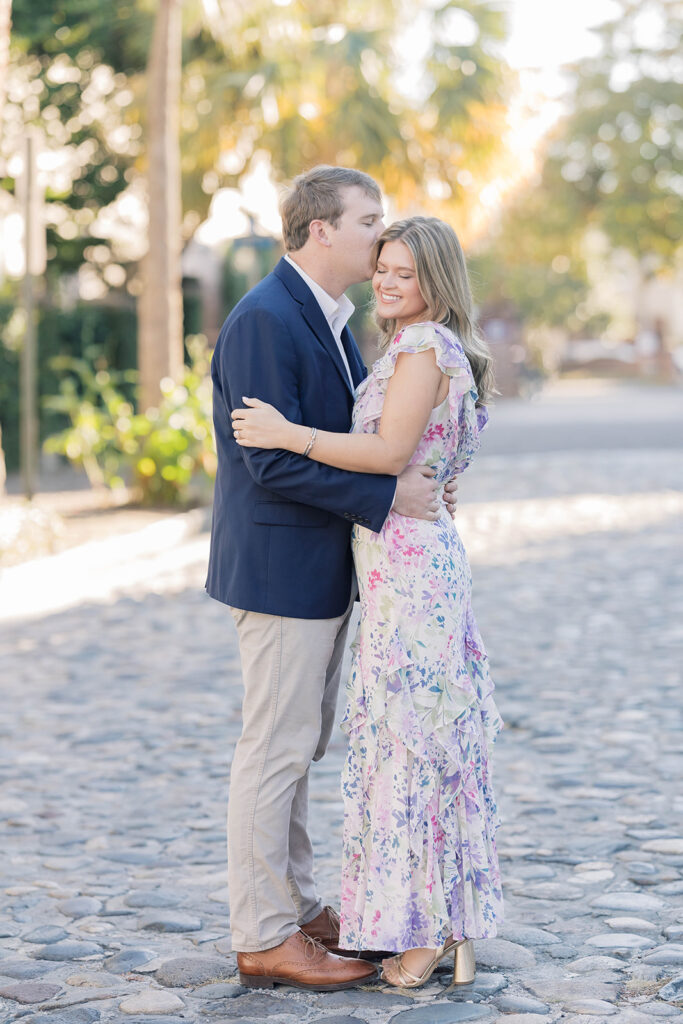 Charleston SC engagement photos | couple hugging and kissing on chalmers street