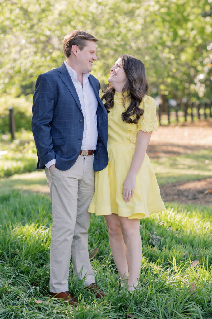 Engagement photographer near me | couple looking at each other in the grass out sc statehouse