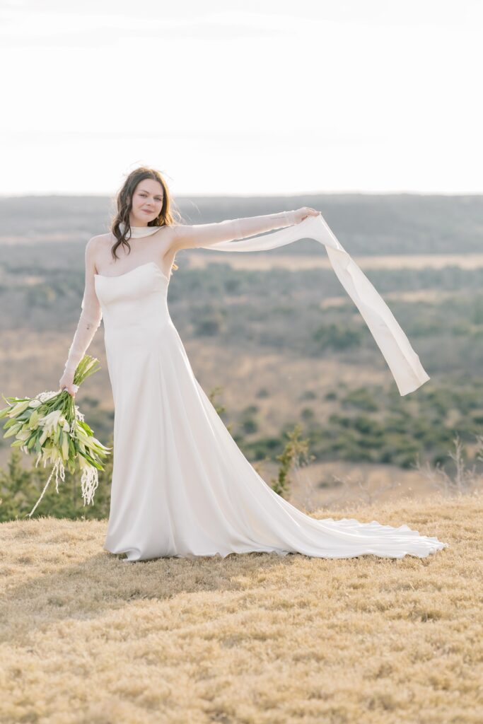 Bridal Portraits | Bride having fun with the wind blowing her dress. Elopement at Contigo Ranch in Fredericksburg Texas