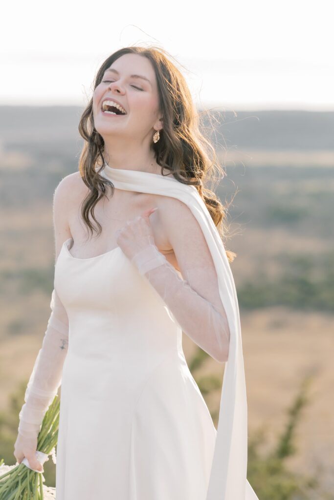 Bridal Portraits | Bride on wedding laughing on top of mountain. Elopement at Contigo Ranch in Fredericksburg Texas