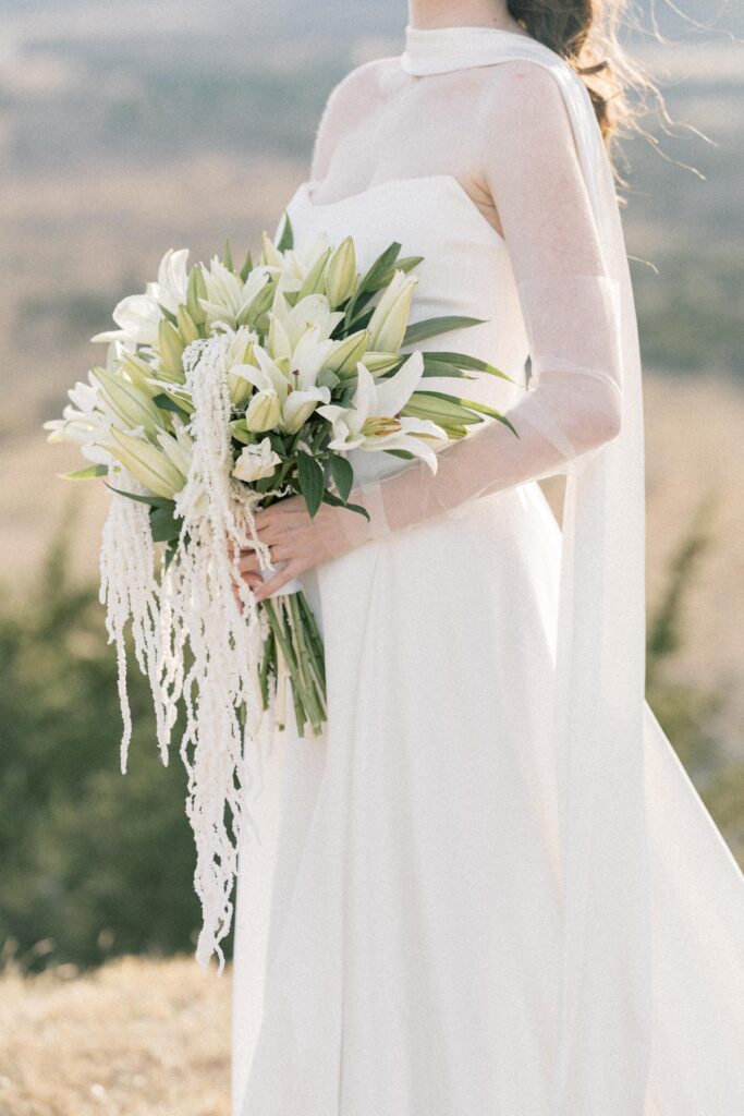 Bridal Portraits | Photo of bride holding white lily floral bouquet. Elopement at Contigo Ranch in Fredericksburg Texas