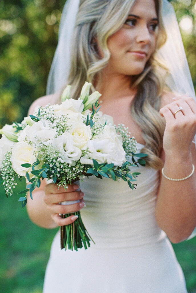 Top Film Photographers in South Carolina for Your Wedding | Bride holding bouquet and veil, looking away in Charleston South Carolina. Photographed in 35mm color fuji 400 film.