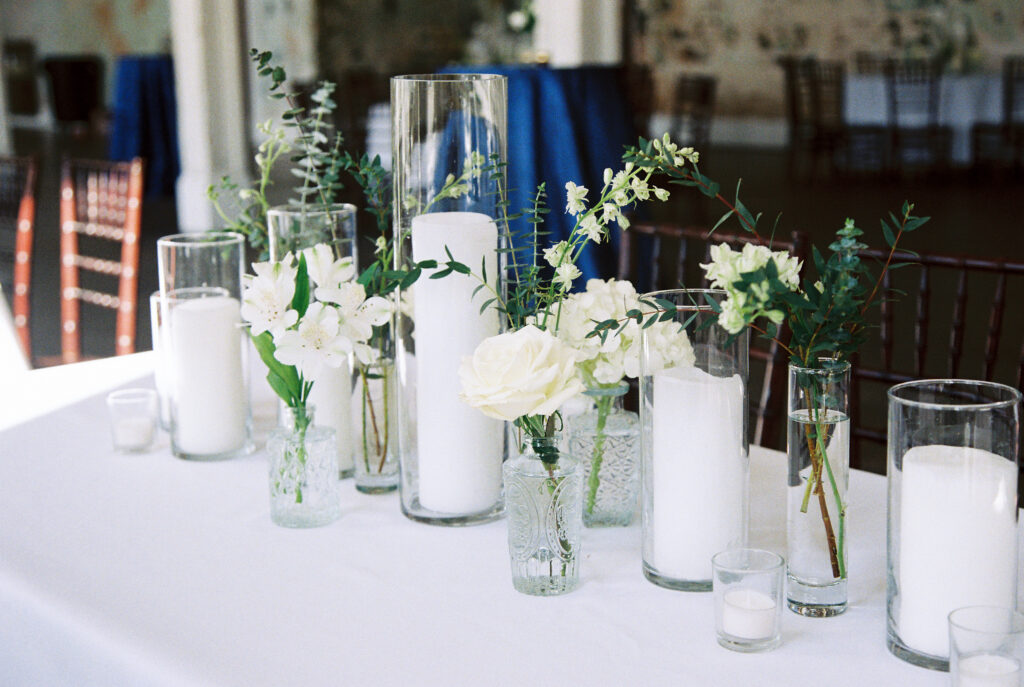 Film Photographer | Photo of wedding decor with white florals and candles in different size glasses. 35mm color film photographed before wedding. Wedding photos at 701 Whaley in Columbia, South Carolina.