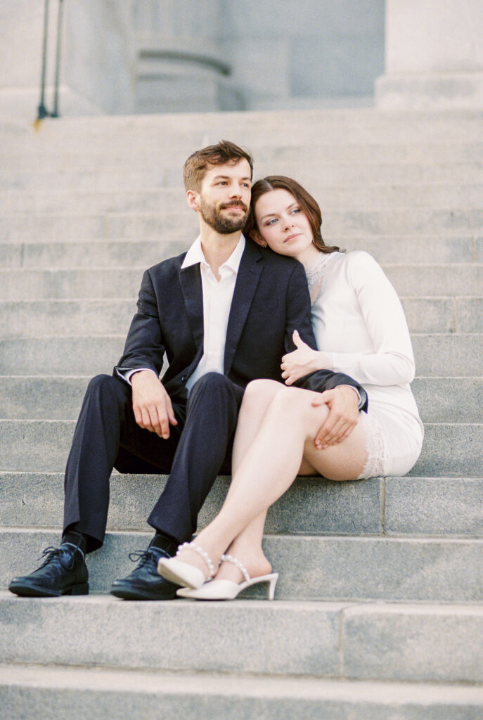 Film Photography | Couple looking out during engagement session in Columbia, South Carolina. Couple is sitting on the steps of the SC Statehouse. Photographed in 35mm color film.