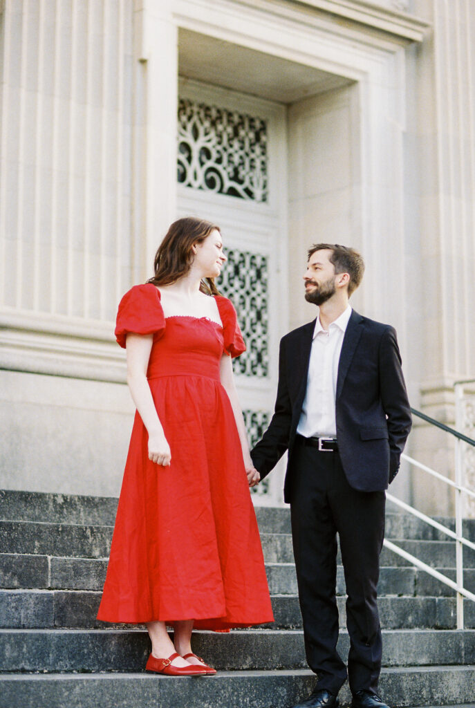 Film Photography | Couple holding hands on stairs in Charleston South Carolina. Photographed during engagement session. Photographed in 35mm color film.