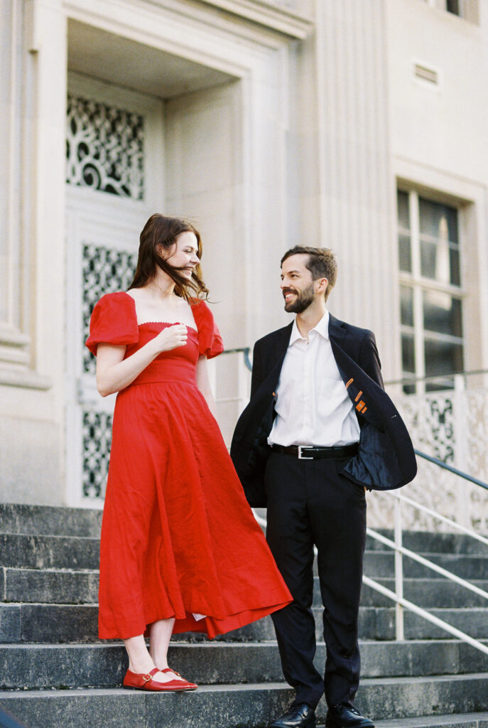 Film Photography | couple looking at each other with the wind blowing in Charleston South Carolina. Photographed during engagement session. Photographed in 35mm color film.