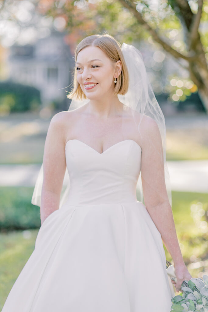 Bridal Portraits | Bride looking away and holding her bouquet. Warm summer day in Charleston, SC.