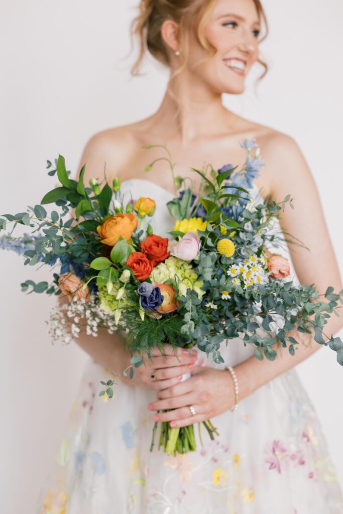 Bridal Portraits | Bride holding bridal bouquet with bright colors at 701 Whaley Studio