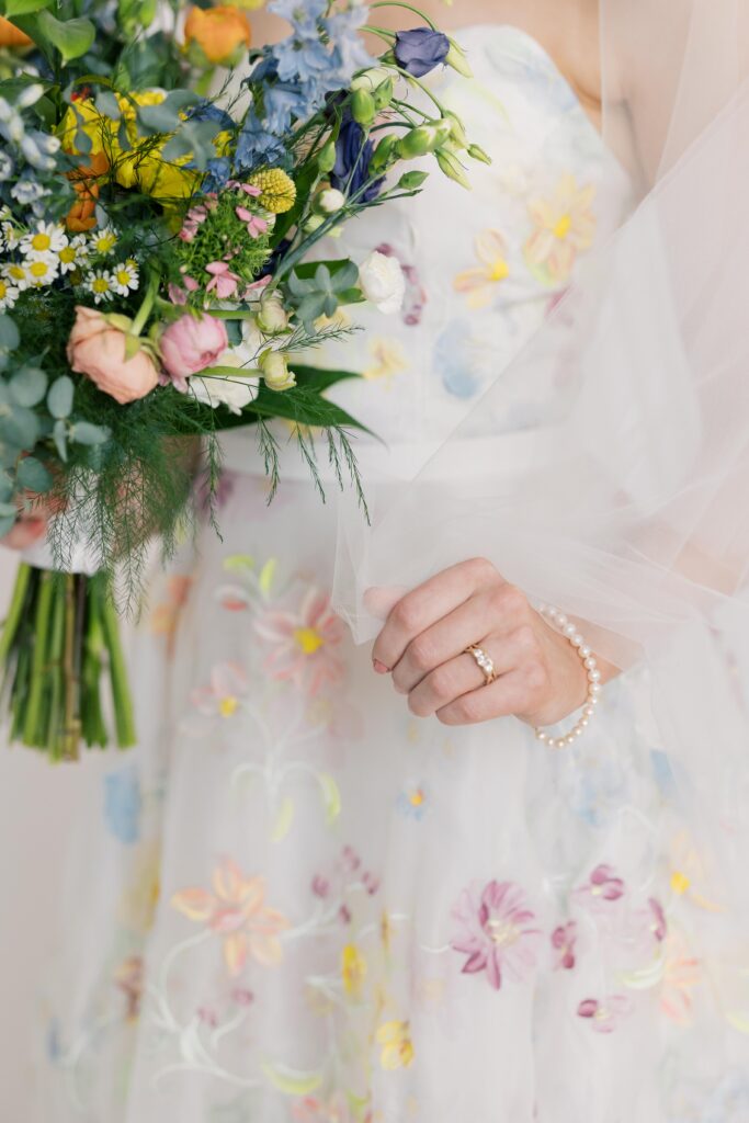 Bridal Portrait | Floral wedding dress with bride showing ring, veil and bridal bouquet at 701 whaley studio