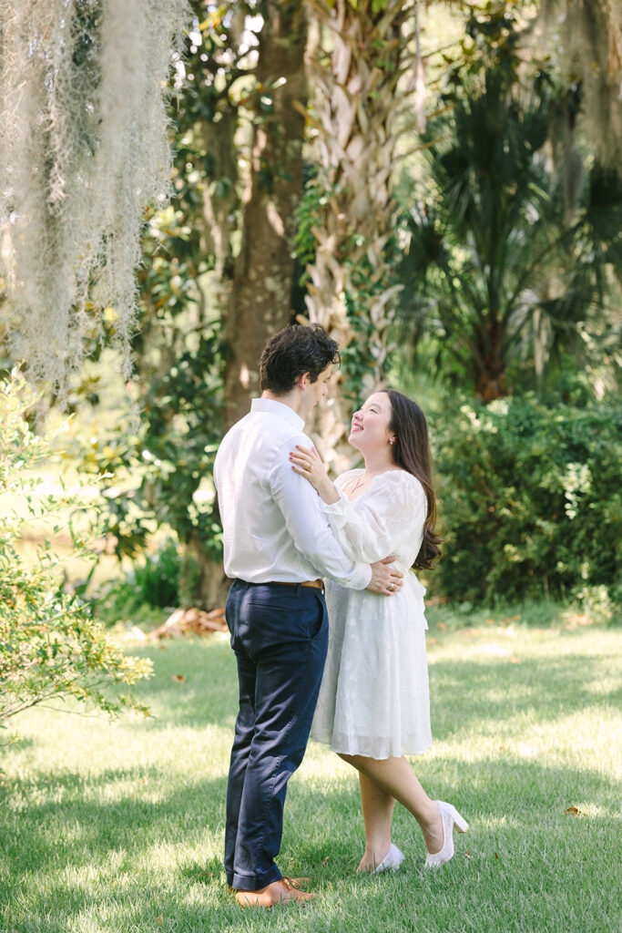 Charleston engagement photographers | Engagement session in Charleston SC | couple smiling at each other in green space