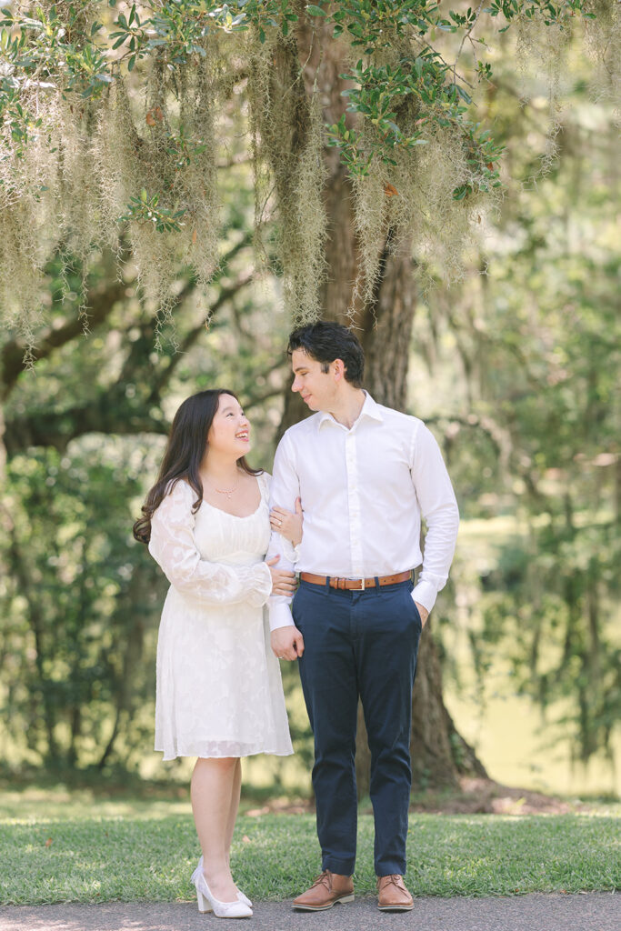 Charleston engagement photographers | Engagement session in Charleston SC | couple looking at each other under a tree covered in spanish moss