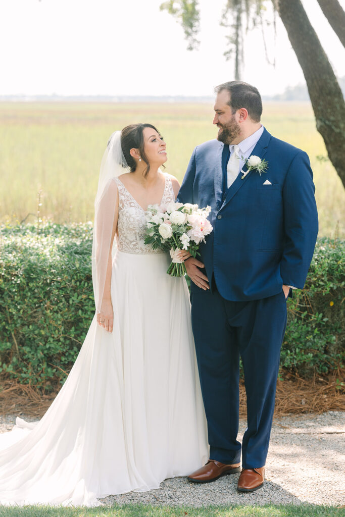 Charleston wedding Photographer | Creek at Ion Wedding | Bride and groom smiling at each other after wedding in front of marsh