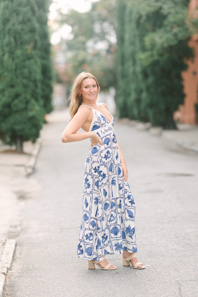 Charleston Senior Pictures | Senior Session in Charleston SC | senior in blue and white dress standing in the road lined with tall green trees