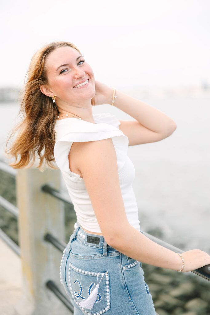 Charleston Senior Pictures | Senior Session in Charleston SC | Senior smiling at camera in front of water at riverfront park