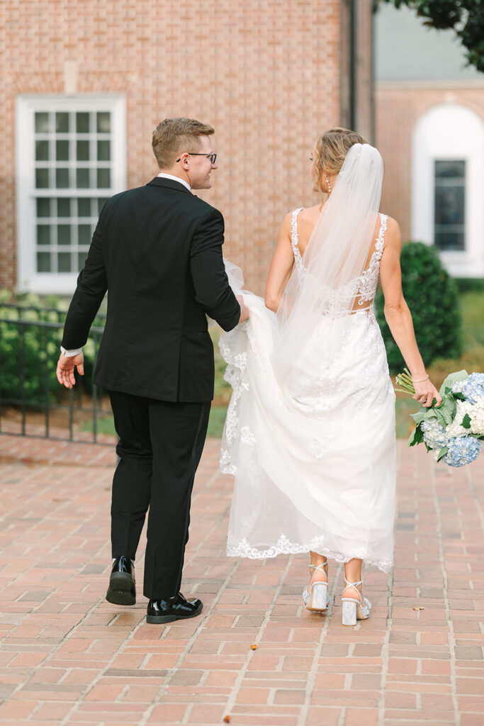 Columbia South Carolina Photographer | 701 Whaley Wedding|  bride and groom walking, groom holding brides dress