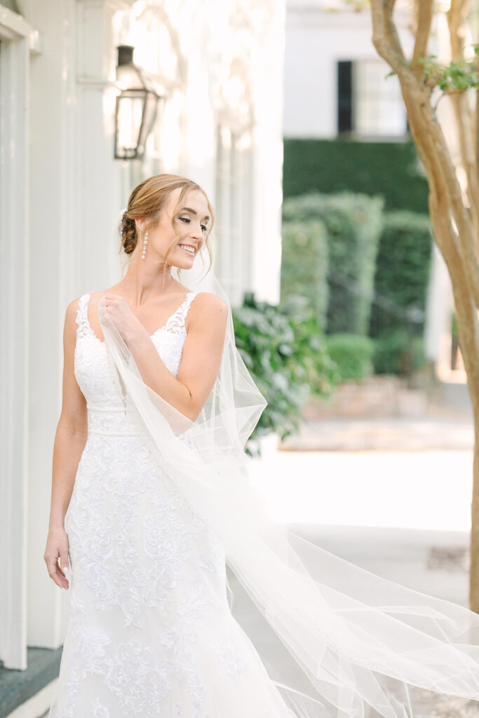 bridal portraits in Charleston | bride holding veil by historic home