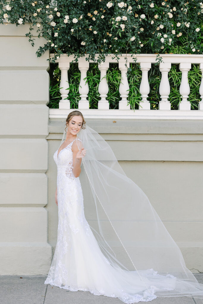 Charleston bridal portrait locations | Bride holding veil in the wind near rainbow row