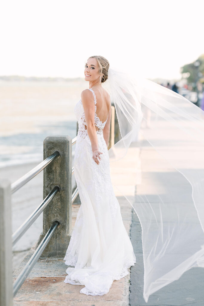 Charleston bridal portrait locations | Bride holding veil at waterfront near the batter