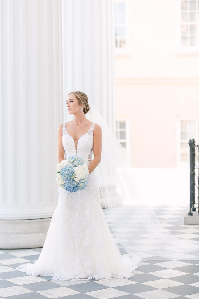 bridal portraits in Charleston | bride looking out among the white columns