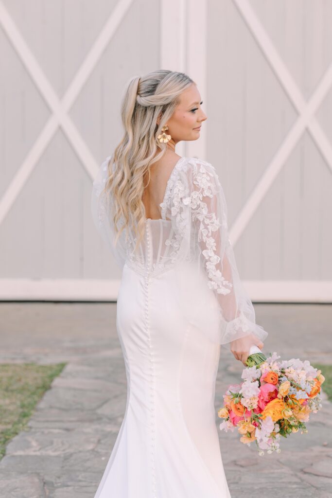 Bridal portrait Mistakes | bride standing in front of ceremony space at tin roof farms