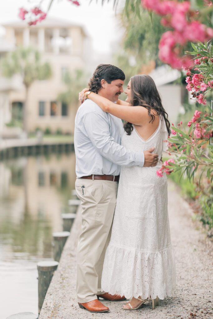 Charleston Wedding Photographer | Engagement Session at Creek at Ion | Couple wrapped around each other smiling beside the creek at ion