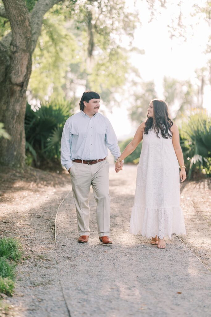 Charleston Wedding Photographer | Engagement Session at Creek at Ion | Couple walking down pathway in Charleston