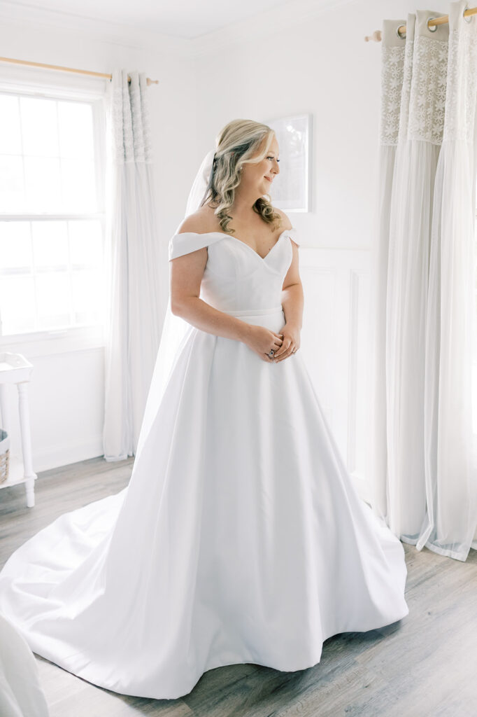 Heron Hill Wedding Venue | Gilbert SC | Chad and Kendall's wedding | Bride in wedding dress looking out the window at her ceremony space
