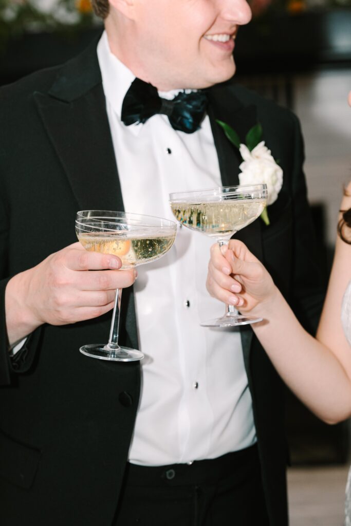 Close-up of a couple toasting with champagne in formal attire, focusing on candid movement and emotion that strong Columbia SC photographers consistently capture.