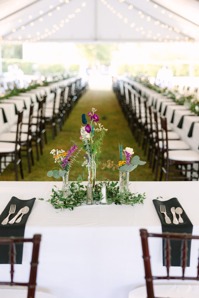 Wedding Reception Venues in Columbia SC | Stee Garman Photography Fine-art Wedding Photographer | Elegant wedding reception in a white tent, featuring long tables with floral centerpieces, string lights overhead, and neatly arranged place settings.