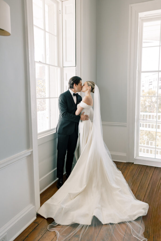 Bride and groom sharing a quiet portrait by tall windows with soft natural light inside a timeless Columbia SC wedding venue.